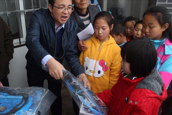 志愿者將學習用具分發(fā)給留守兒童.jpg